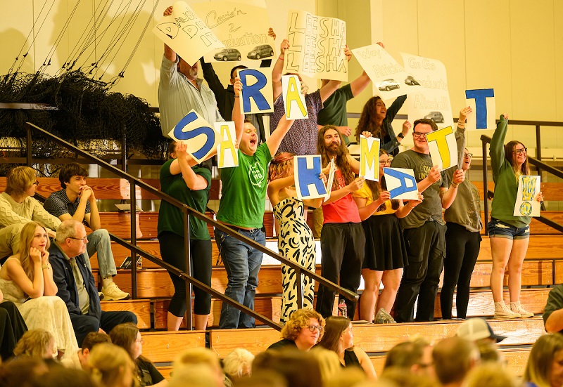 Family and friends hold up signs for graduates at the OHIO Lancaster Graduation Recognition Ceremony