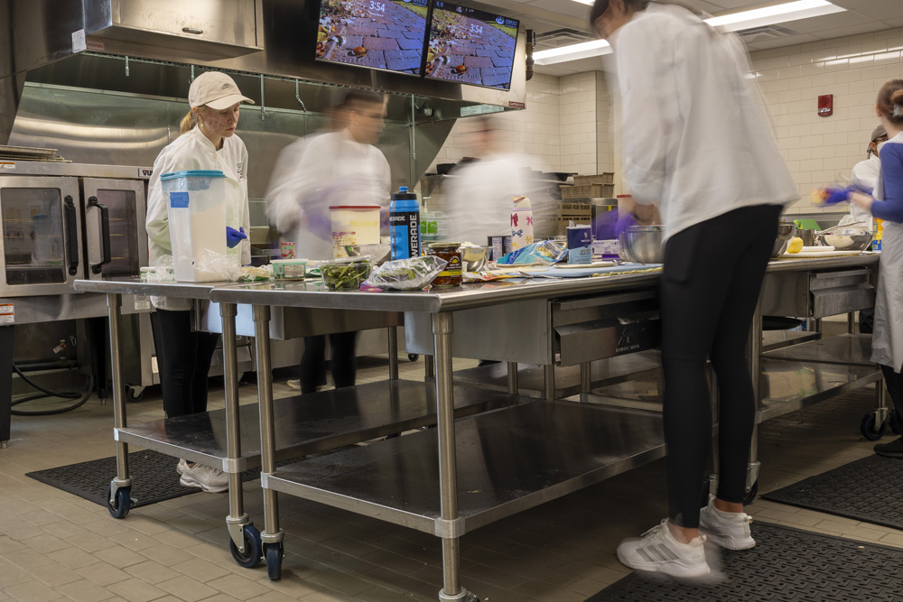 Students moving quickly while preparing food.