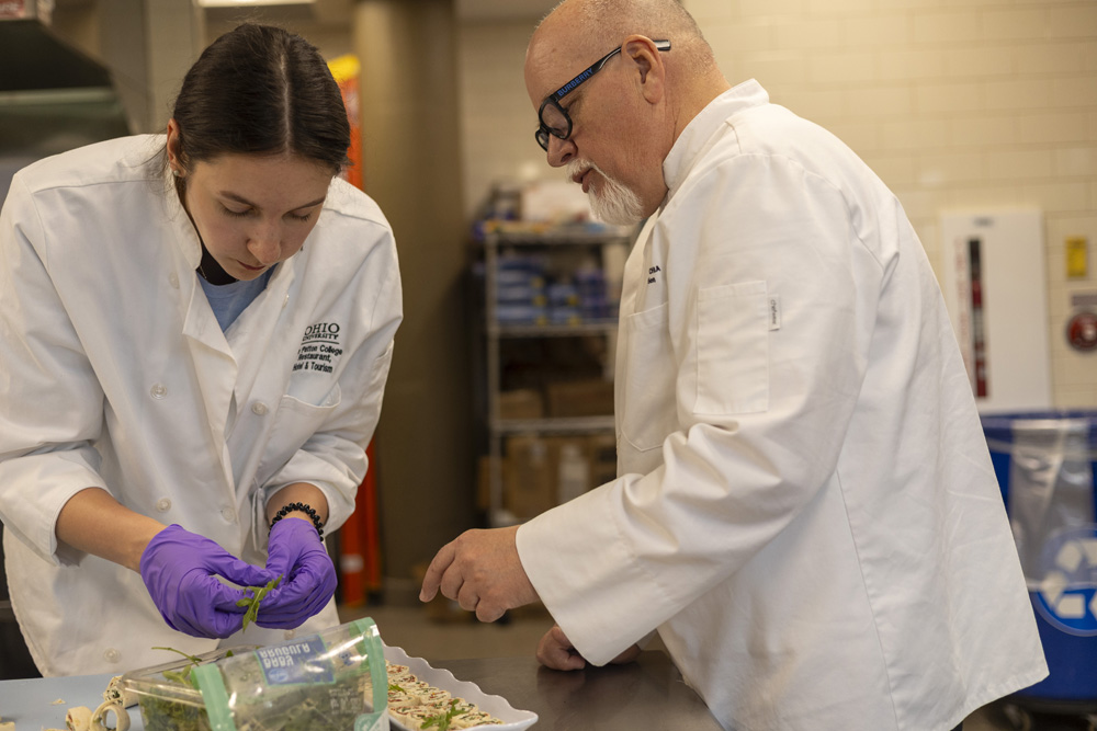 A student and professor Thom Stevenson preparing food.