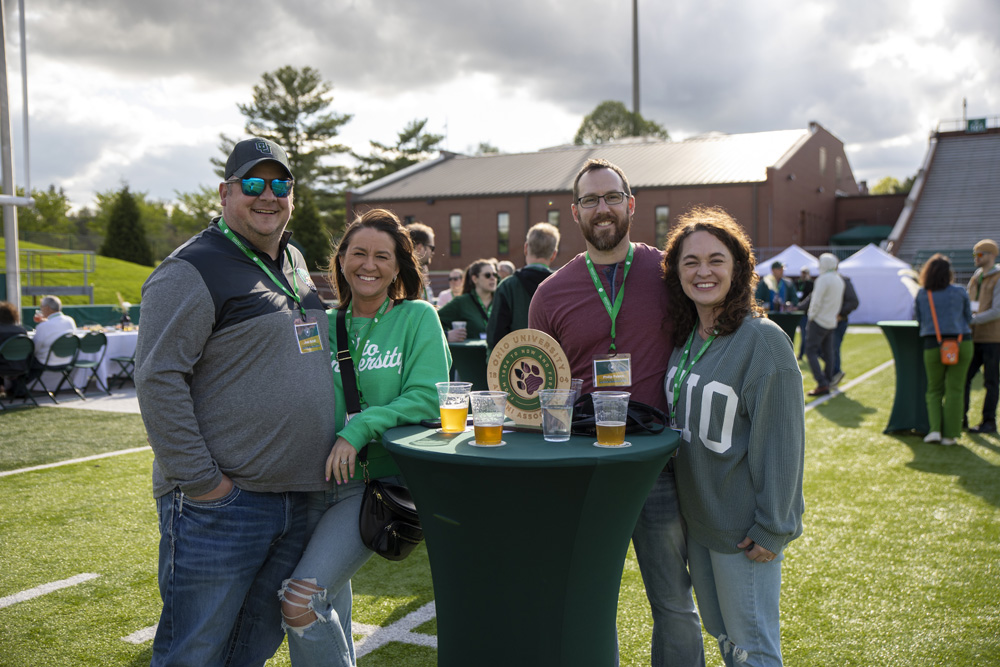 Four people posing at the Taste of Brewing event.