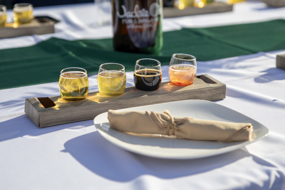 Four beers lined up on a table in taste tester glasses.