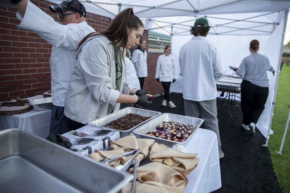 A student prepares food for the Taste of Brewing event.