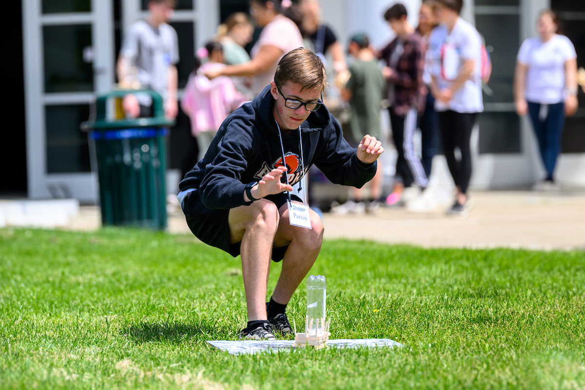 A student gets ready to launch their bottle rocket, putting their design and engineering skills to the test.