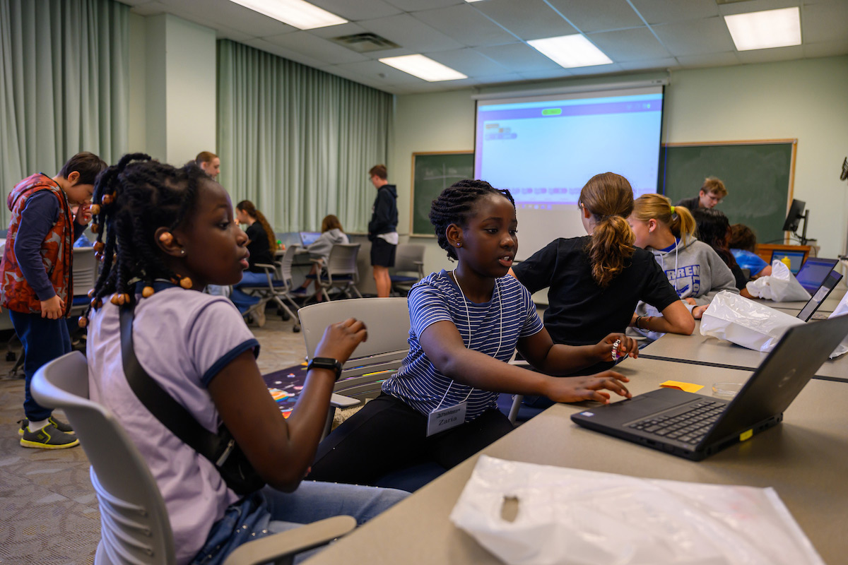 Teams of students collaborate to program their Sphero robots, navigating the game mat to reach planets like Jupiter through coding challenges at Tech Savvy Day 2025.