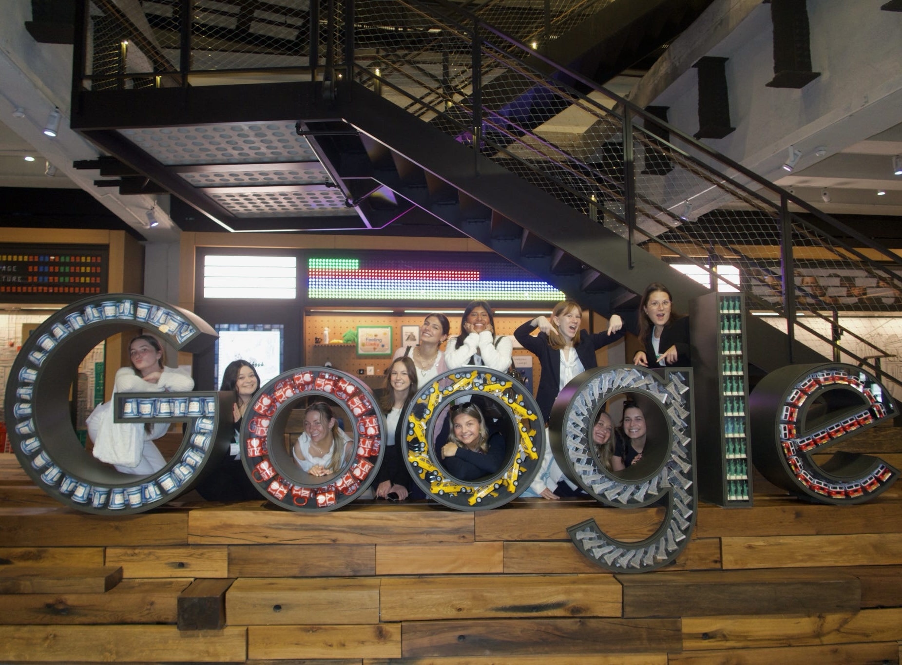 college students pose with a life-size Google logo statue