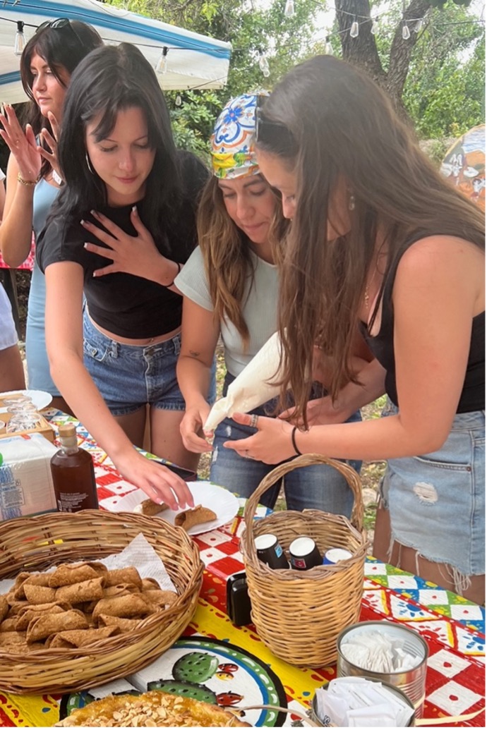(Left-to-right) Nina Motter, Grace Nolen and Caroline Kustra fill cannoli shells with ricotta.