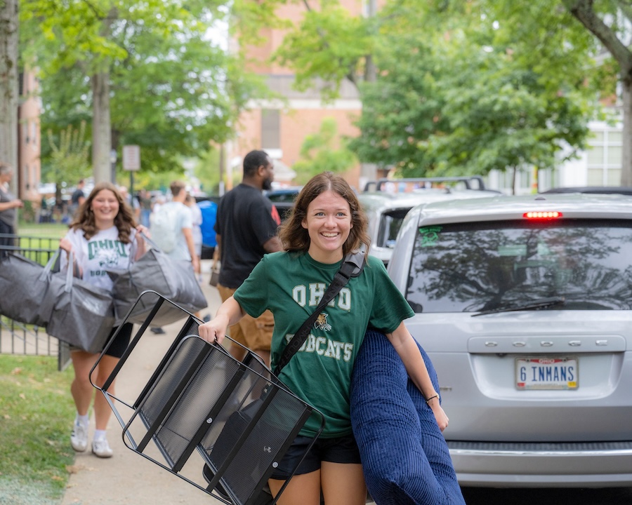 Students carry belongings as they move in to residence halls