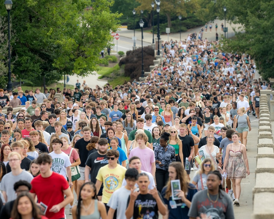 A large group of students walk up Richland Avenue