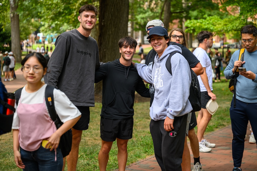 Three students pose for a photo, smiling