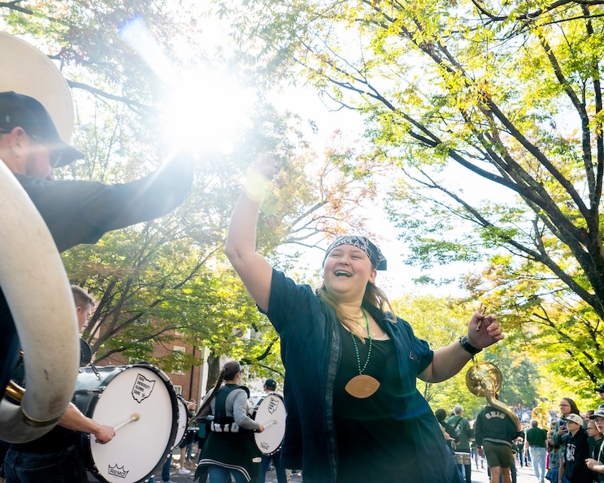 An OHIO fan high-fives a member of the Marching 110