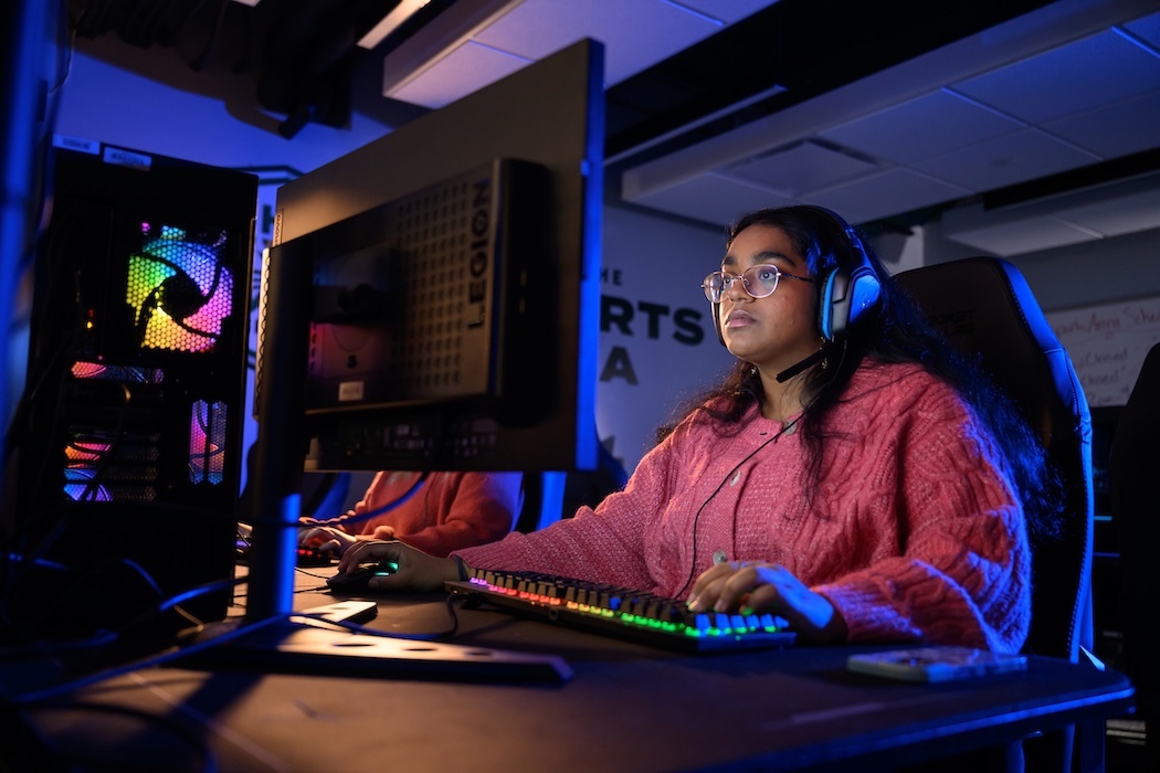 Student, Shrinidhi Vaideeswaran, playing a pc game in the university esports arena 