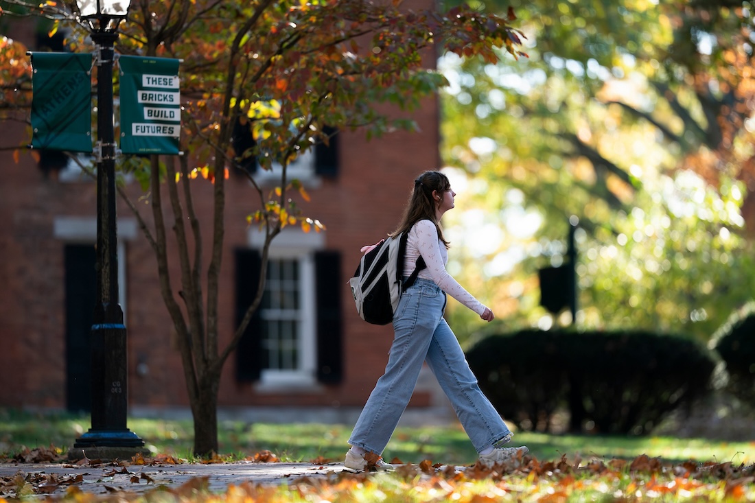 A student walks across College Green