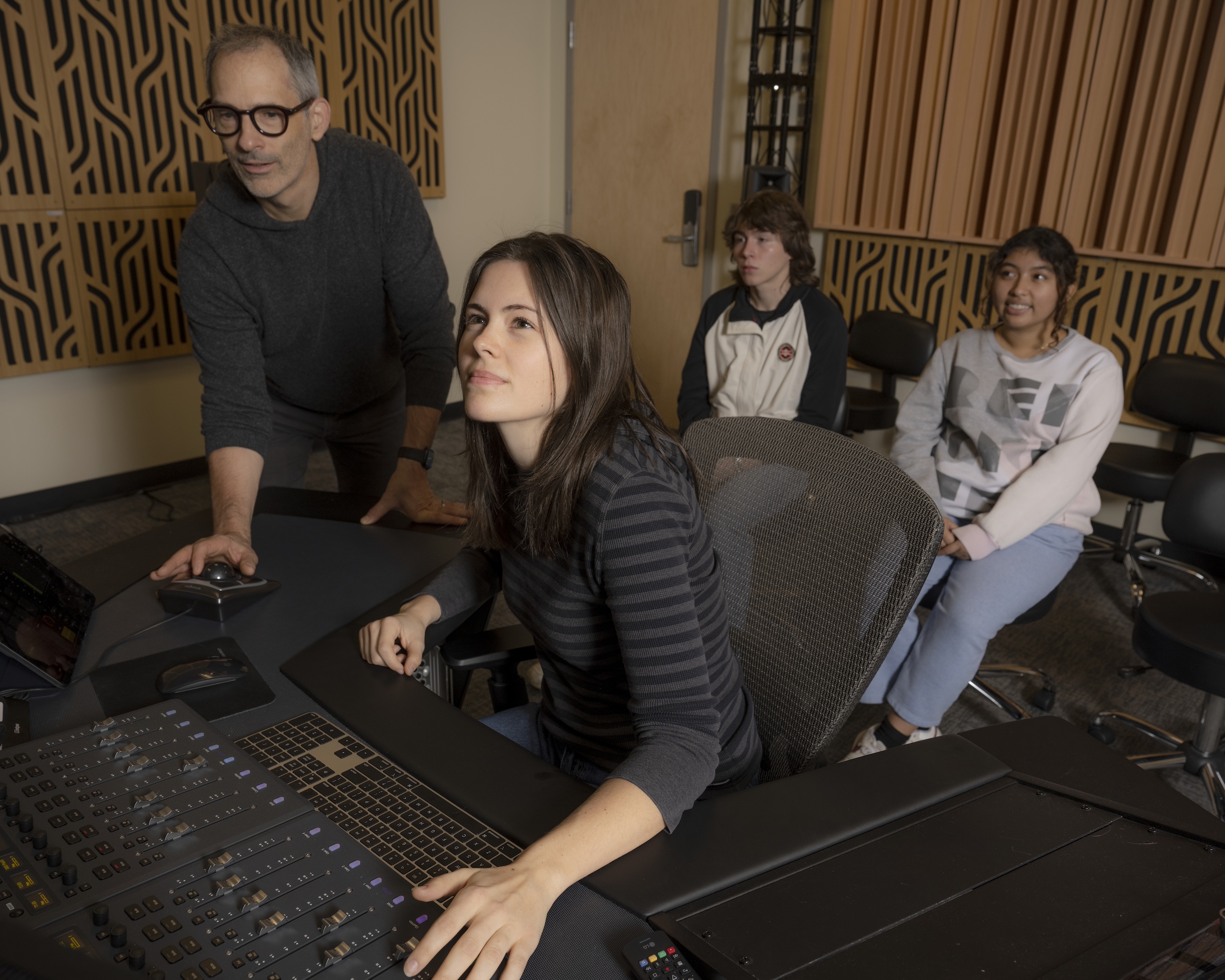 Students work in recording studio with professional