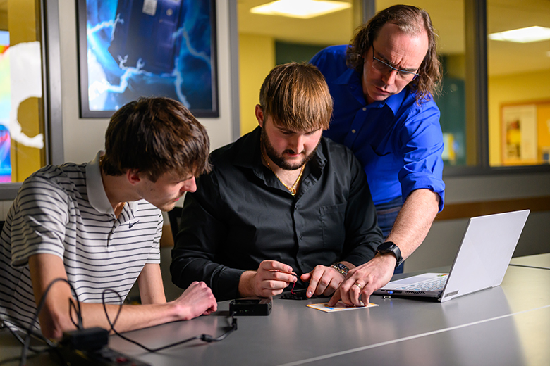 Brandon Saunders works with cybersecurity students.
