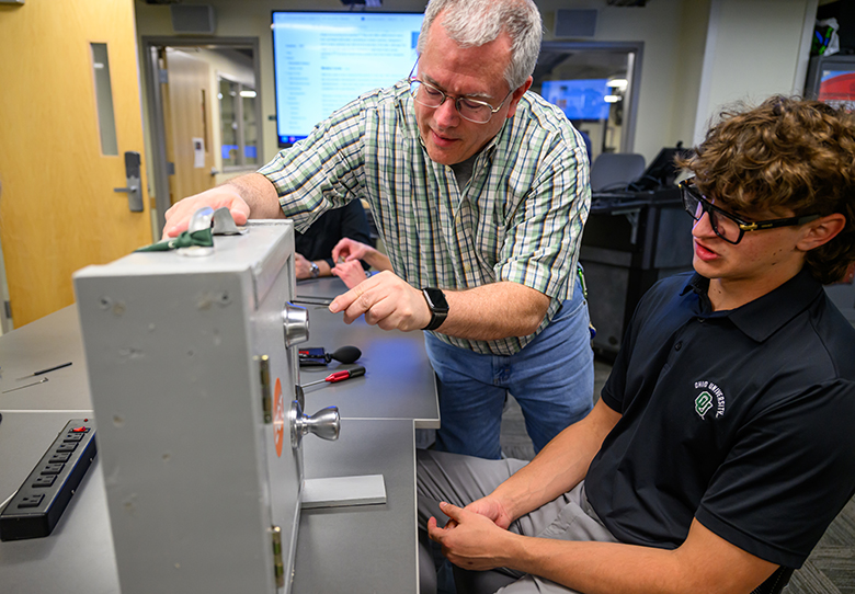 Bruce Tong works with cybersecurity students.