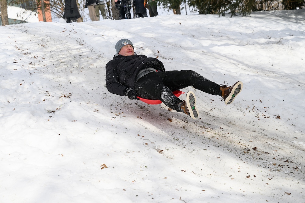 a student catches air sledding down a short rise