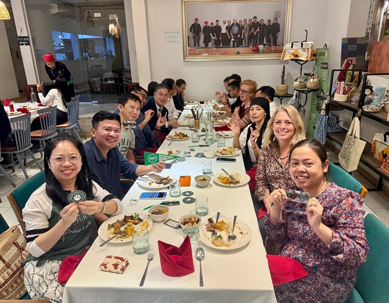 OHIO representatives and OHIO alumni enjoy dinner together, while some alumni hold up OHIO stickers and other items