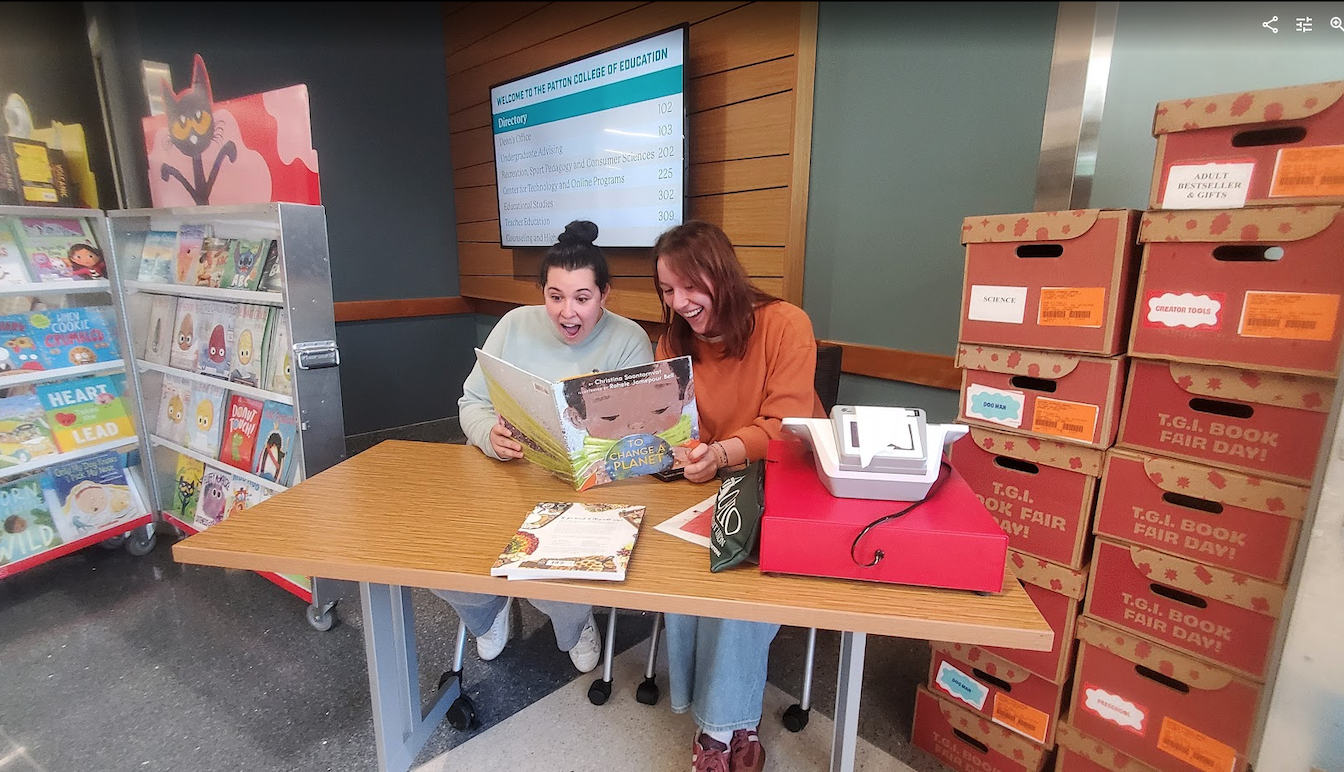 People reading a book at table