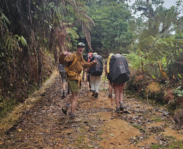 A group of hikers, one facing the camera and smiling.