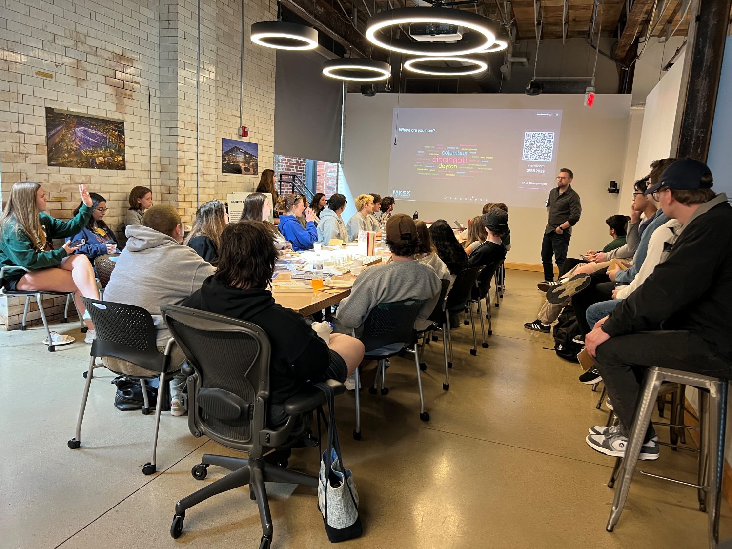 Students in an office listening to Kyle May.
