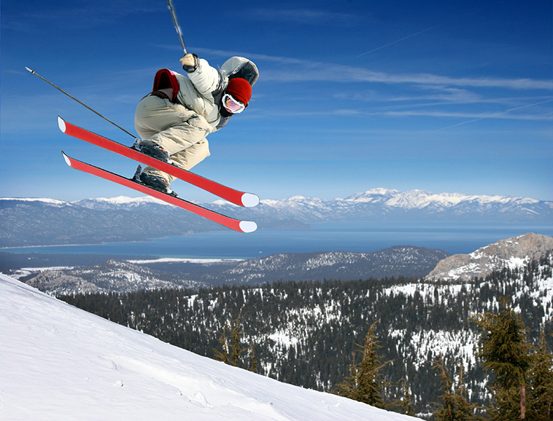 A skier dramatically jumps on the way down a slope.