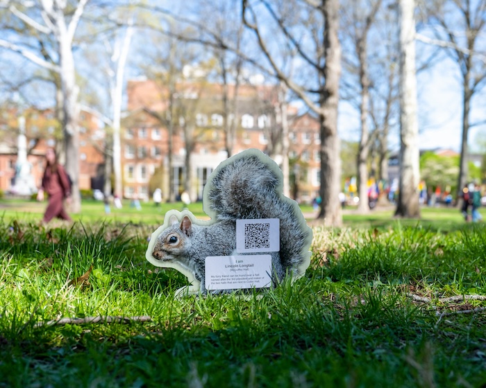An OHIO squirrel image is shown on the College Green with text and a QR code on it. It is part of the scavenger hunt.