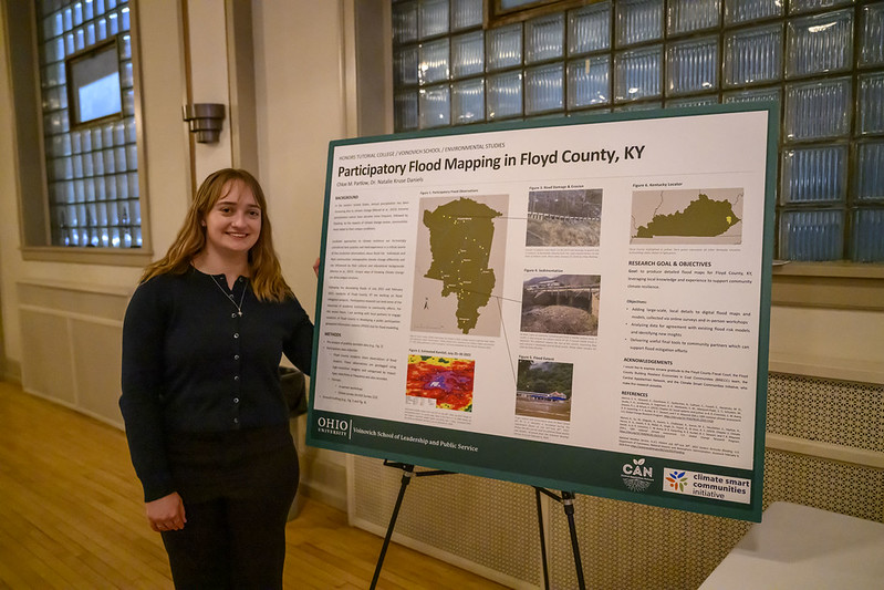 An OHIO student shows the poster for the research presentation "Participatory Flood Mapping in Floyd County, KY"