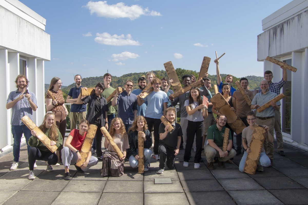 Students holding pieces of the Embarie, a large, wooden instrument similar to a marimba. 
