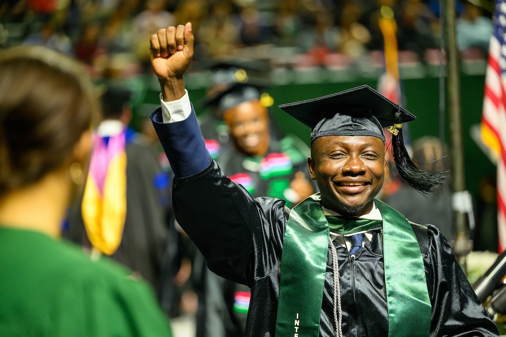 A student celebrating at the spring 2026 graduate Commencement ceremony