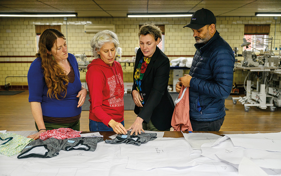 Founder Betsy Franjola (third from left) reviews garment patterns and sample pieces with collaborators.