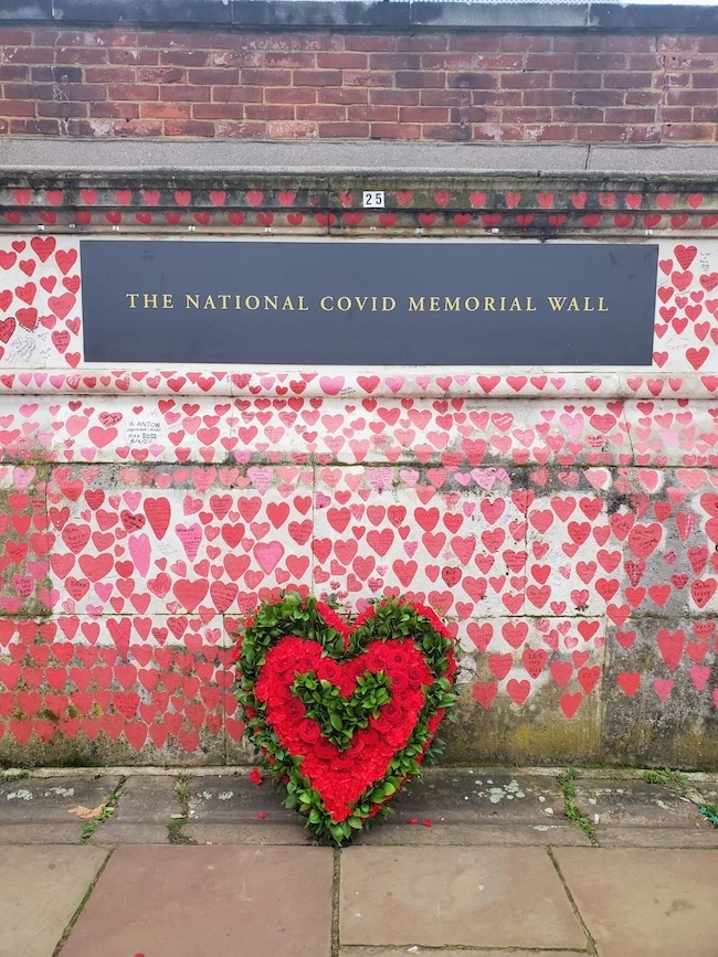 The Covid memorial in London, a heart-shaped wreath leaned against a brick wall