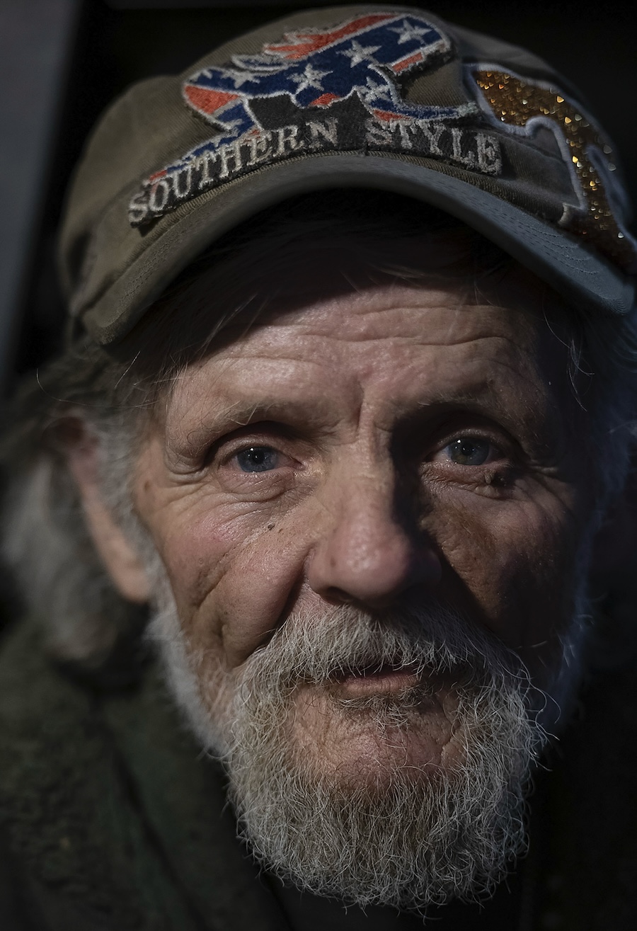 A portrait of a man with a beard, wearing a baseball hat.