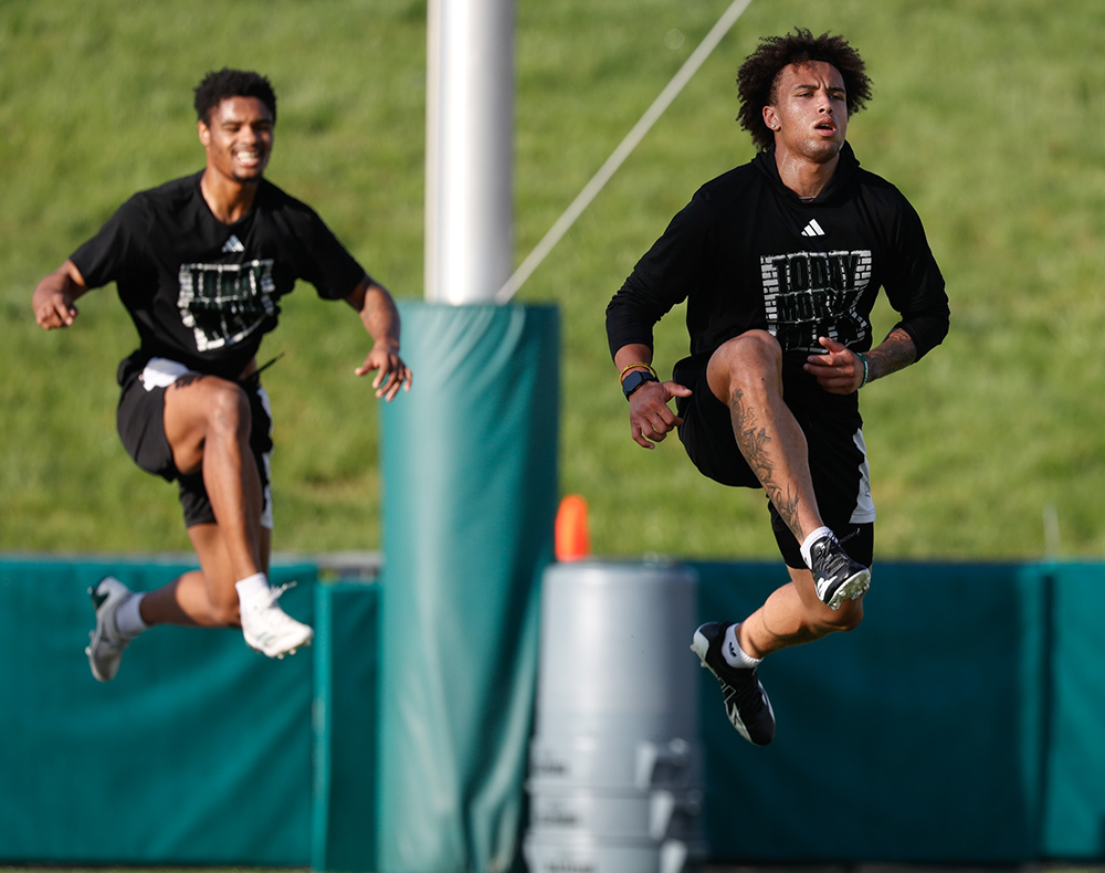 Wide receivers Khamani Debrow and Dom Dorwart leap during an outdoor OHIO football practice drill.