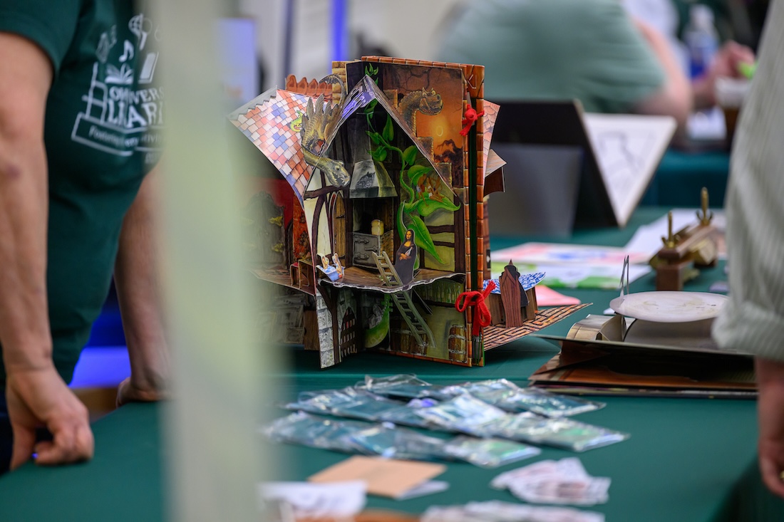 A model of a whimsical house is on display at a resource fair