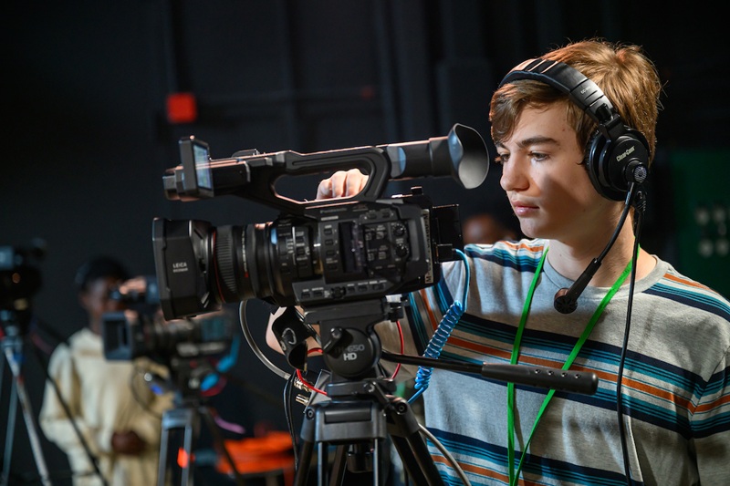 A participant at the workshop looks into the camera while recording video inside a studio