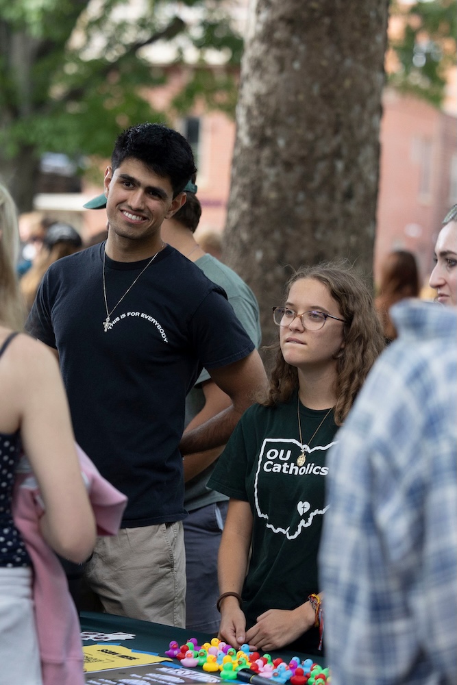 two students hear from someone at the campus involvement fair