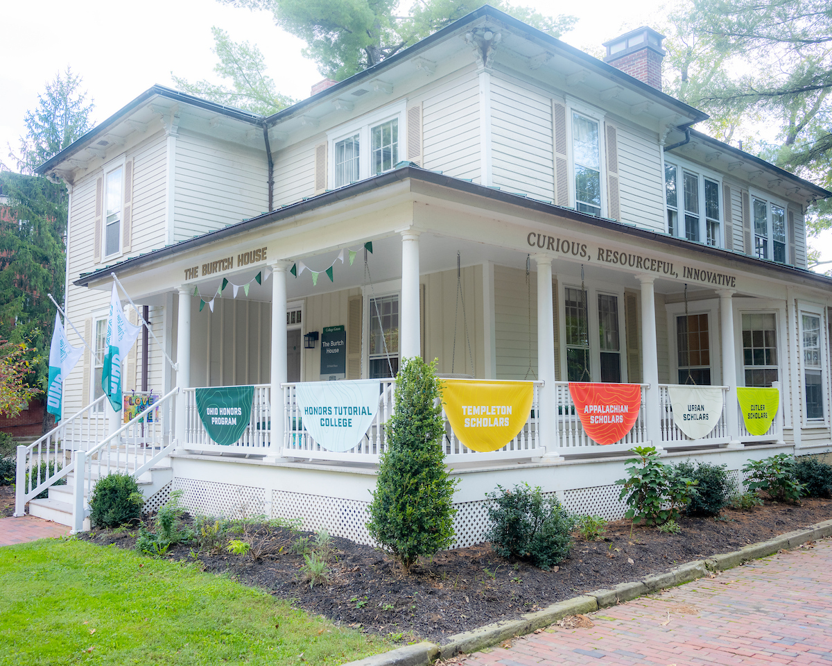 The outside of The Burtch House with signage on the front porch that says "The Burtch House. Curious, Resourceful, Innovative"