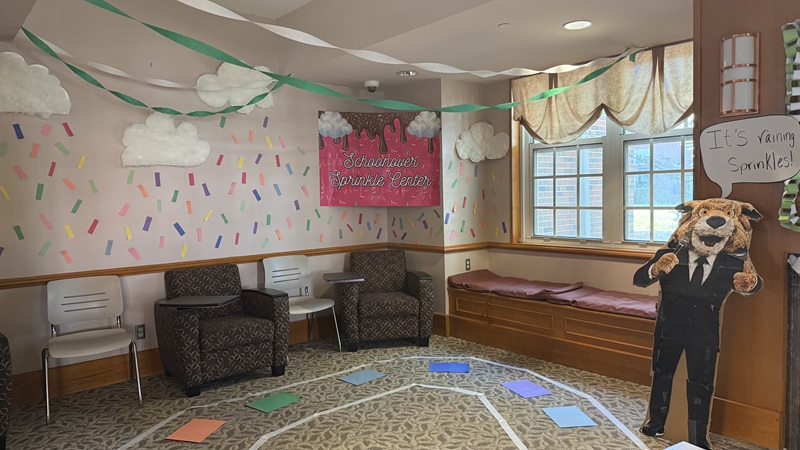 A room that is decorated with cutout of a Rufus mascot saying "It's raining sprinkles"and a sign that says Schoonover Sprinkle Center