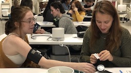 Students from Marietta High School receive a lesson from Debra Cox of the School of Nursing on taking vital sign readings.