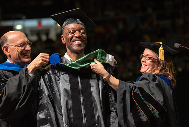 Jack Marchbanks, who received his doctoral degree in history, is hooded by Dr. Robert Frank, dean of OHIO’s College of Arts and Sciences, and Dr. Robin Muhammad, an associate professor and chair of the Department of African American Studies.