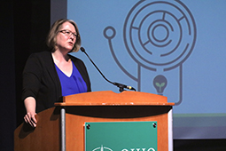 Elizabeth Sayres is shown addressing the attendees at the opening panel discussion.