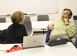 Two course design studio participants engage in discussion.