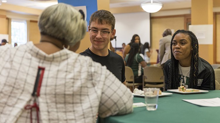 LaWanna McKinley White, BSED ’65, president of the Ebony Bobcat Network’s National Board, chats with some current Ohio University students during the weekend’s Student and Alumni Networking event