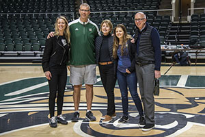 Ann Hebert, BBA ’92, is pictured at center court of the Convocation Center with (from left) Men’s Basketball Coach and fellow OHIO graduate Jeff Boals, BS ’95; her mother, Nancy Vandenberge; her daughter, Grace; and her father, John Vandenberge. Photo by Mack Wagner, BSVC ’21