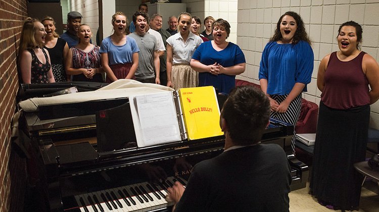 Victor Jones warms up singers backstage during a rehearsal for “Hello, Dolly!” Photo by Ben Wirtz Siegel, BSVC ’02