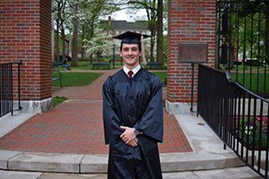 An OHIO alumni tradition, Logan Koshenka, BBA ’18, poses for a picture in front of Class Gateway on the day of his graduation. 