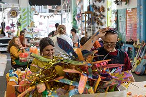 Stephanie Robinson, production manager and volunteer coordinator at Passion Works Studio, works with one of the center’s artists, Dar Whitlatch. 