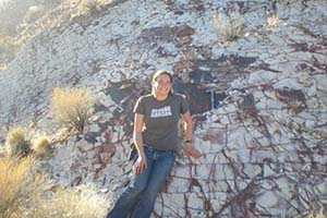 Dawna Roederer, BS ’09, poses for a photo in front of a large shale rock during a field camp trip she participated in while studying geological sciences at Ohio University. 