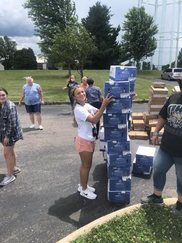 A student distributes boxes of food.