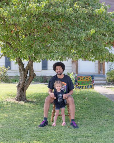 Athens resident Brandon Thompson poses with his daughter in front of their yard sign